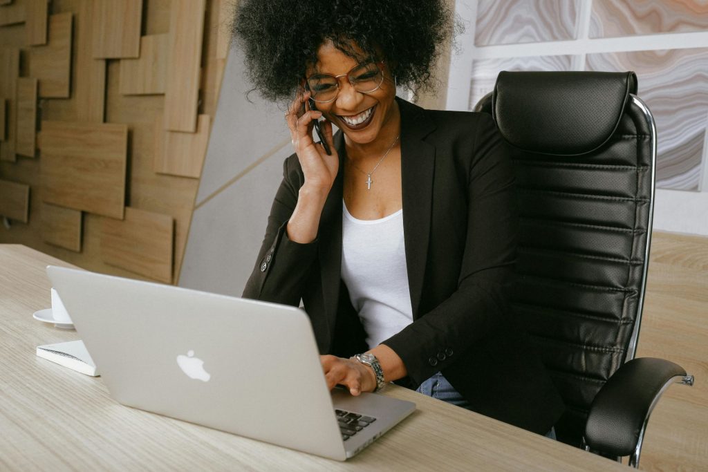 Woman working on a laptop and talking on a mobile phone