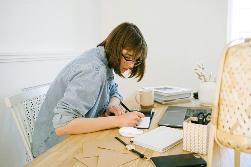 woman sitting at a desk writing 