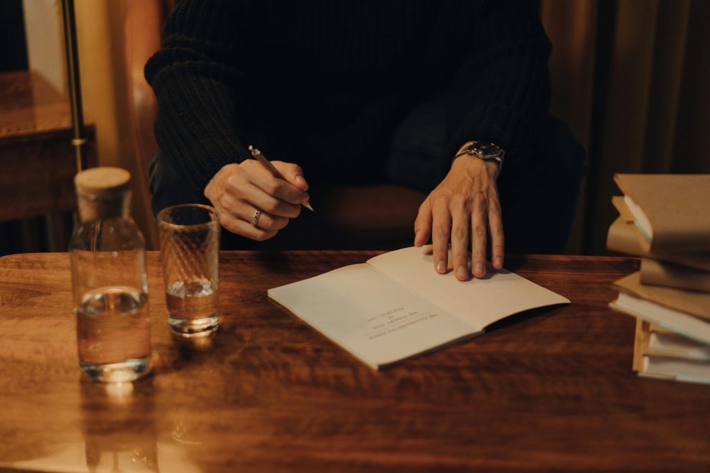 book open to first page with pen in hand