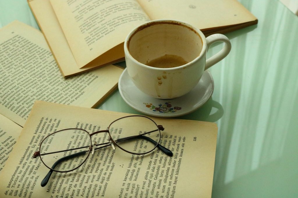 books open with empty coffee cup and glasses