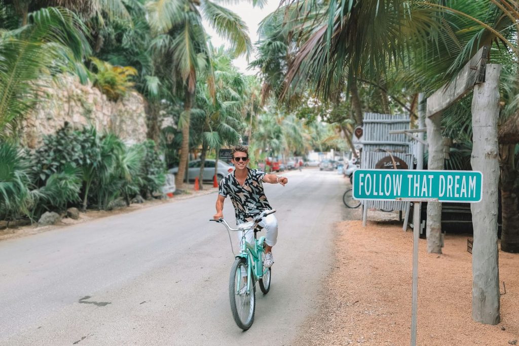 man on a bicycle pointing to a sign