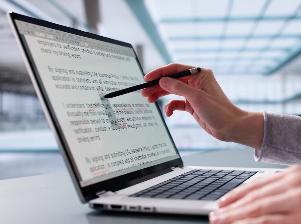 person editing on a touch screen laptop
