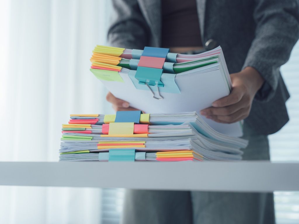 person picking up stacks of papers