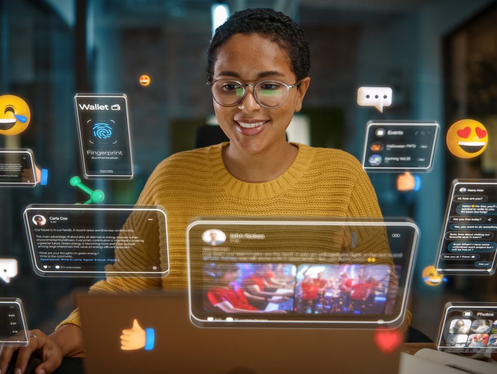 Beautiful Short Haired Project Manager Working on Computer in Office. Augmented Reality Social Media Icons Appear From Worker's Laptop. Internet of Things, Connectivity and Online Concept.