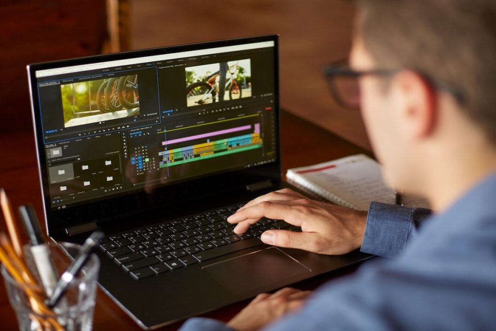 man editing a video on laptop