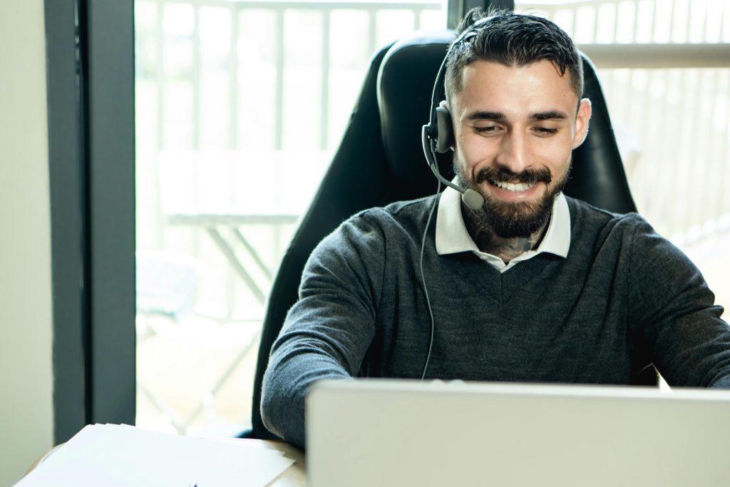 man with headset works on laptop