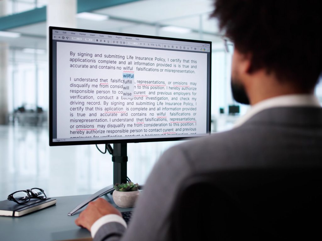 Young African American man edits document at a desktop computer