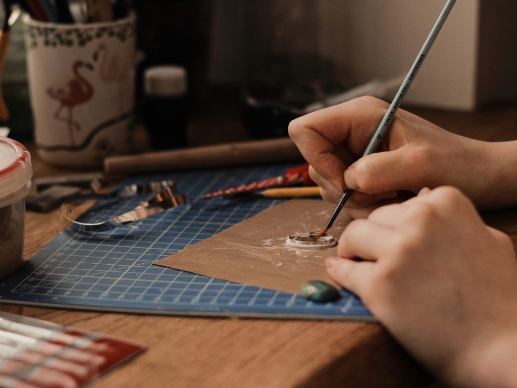 painting a small clay disc
