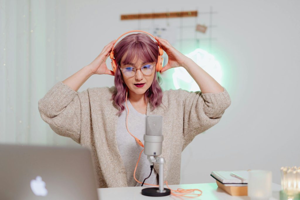 woman putting on headphones in front of a microphone