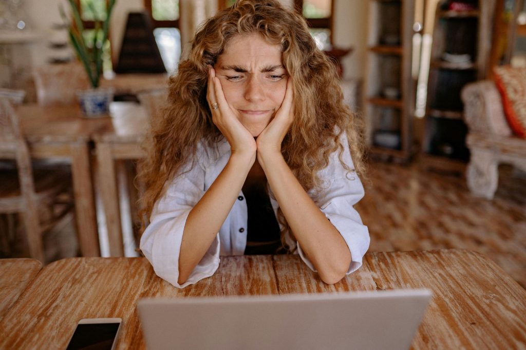 woman sitting at a table with her head in her hands