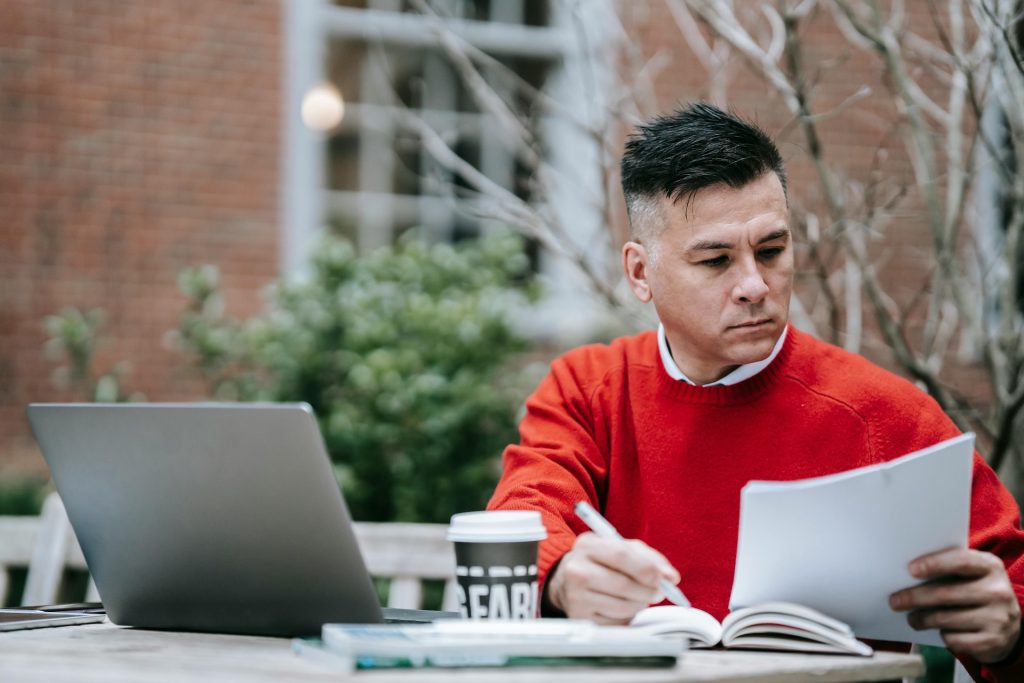 proofreader working on paper and on laptop