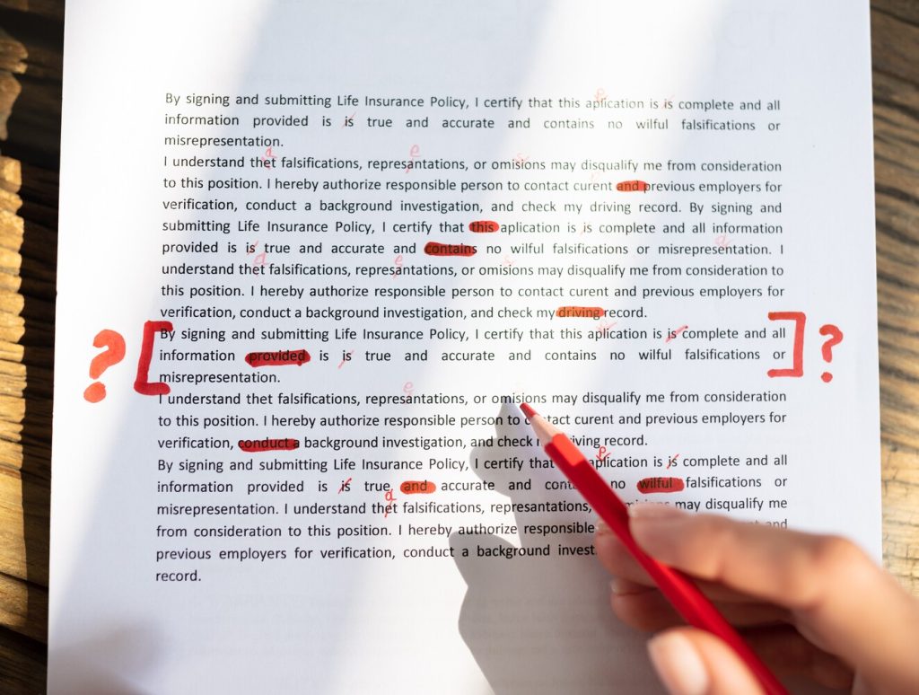 Close-up Of A Person's Hand Marking Error With Red Marker On Document