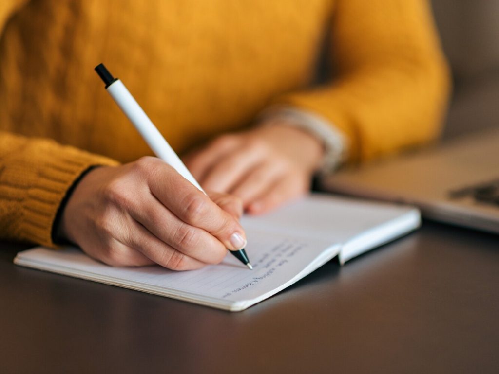 Writing in notebook. Close-up.