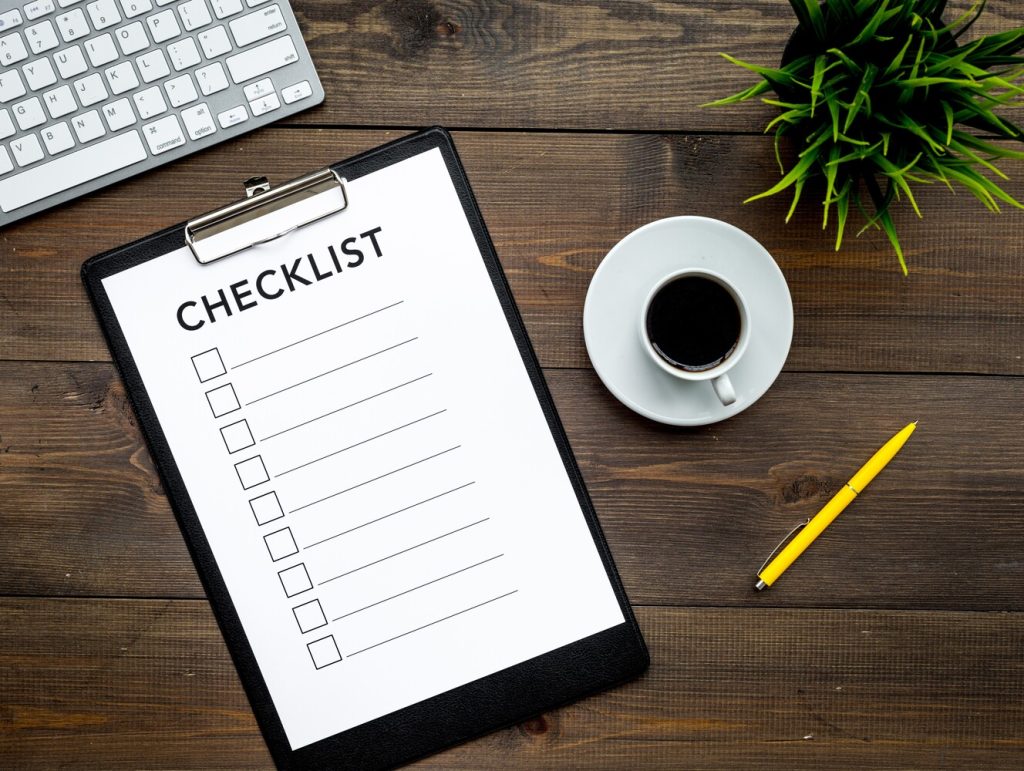 Blank checklist with space for ticks on pad on office desk. Checklist for office worker, manager, businessman, chief on dark wooden background top view
