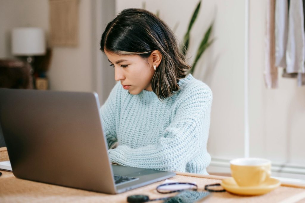 lady with dark hair focusing on a laptop computer