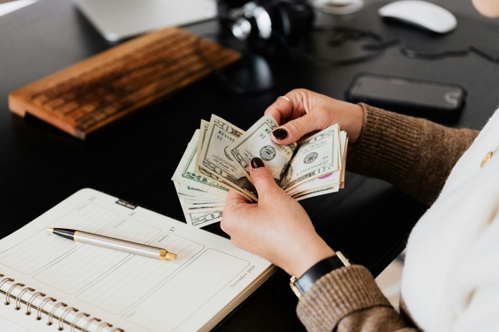 person counting dollar bills