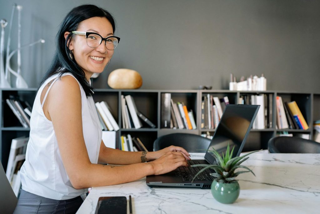smiling woman working at her laptop on a desk