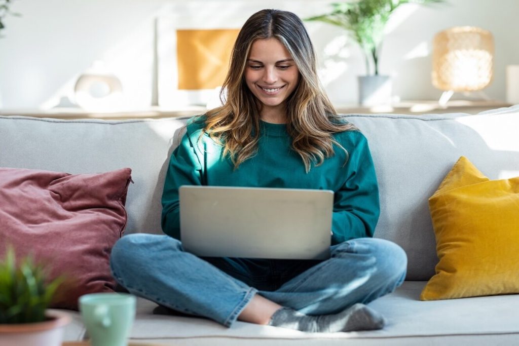 woman at home smiling at laptop