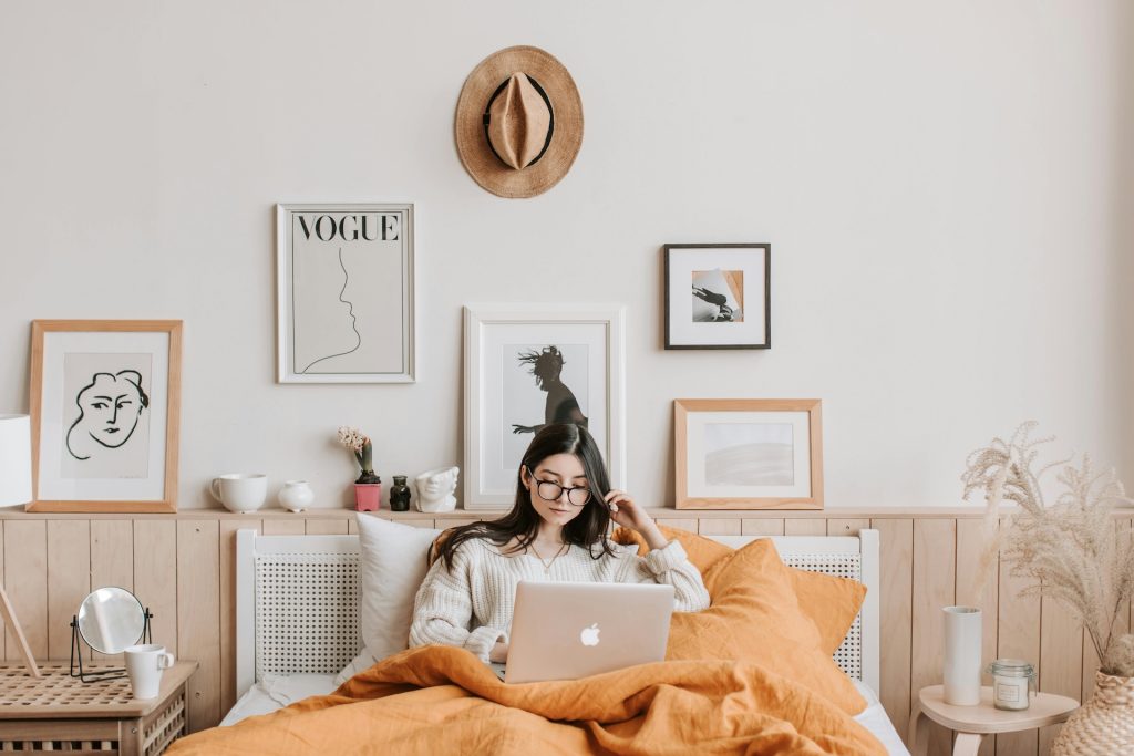 woman copy editing on laptop in bed