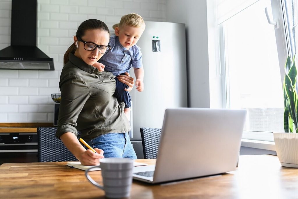 woman working and taking care of toddler simultaneously