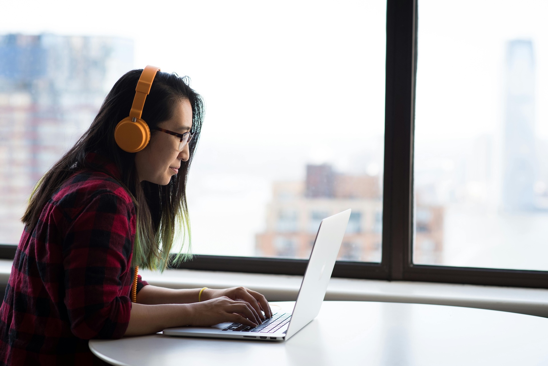 woman working on laptop wearing headphones