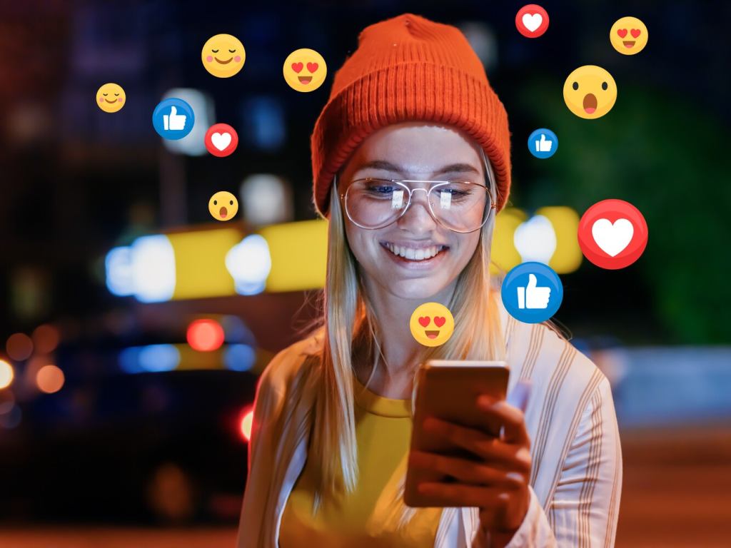 woman smiling at phone with emojis