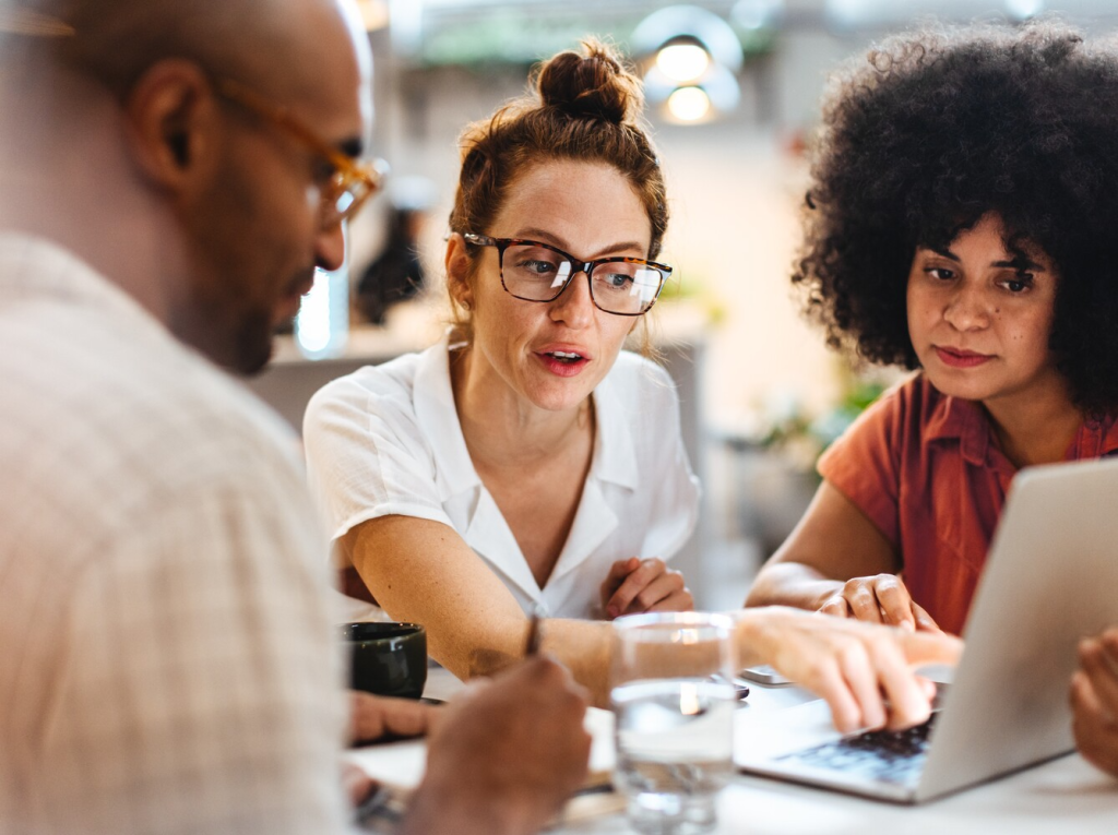 three people working together on a laptop